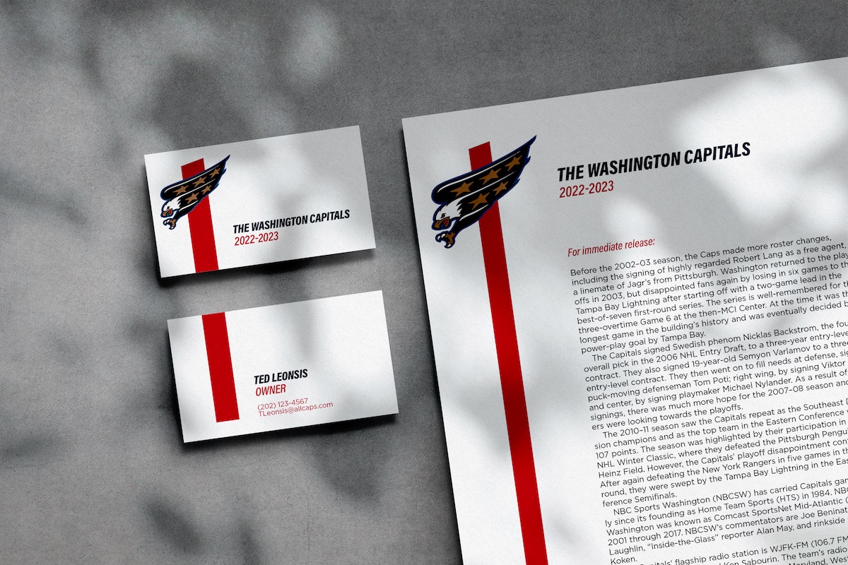 A mockup of a concrete surface with some light speckled over a matching business card (front and back) and printed memo. Both of them feature a logo of an eagle in flight over a bold, red stripe and easy-to-read sans serif fonts.