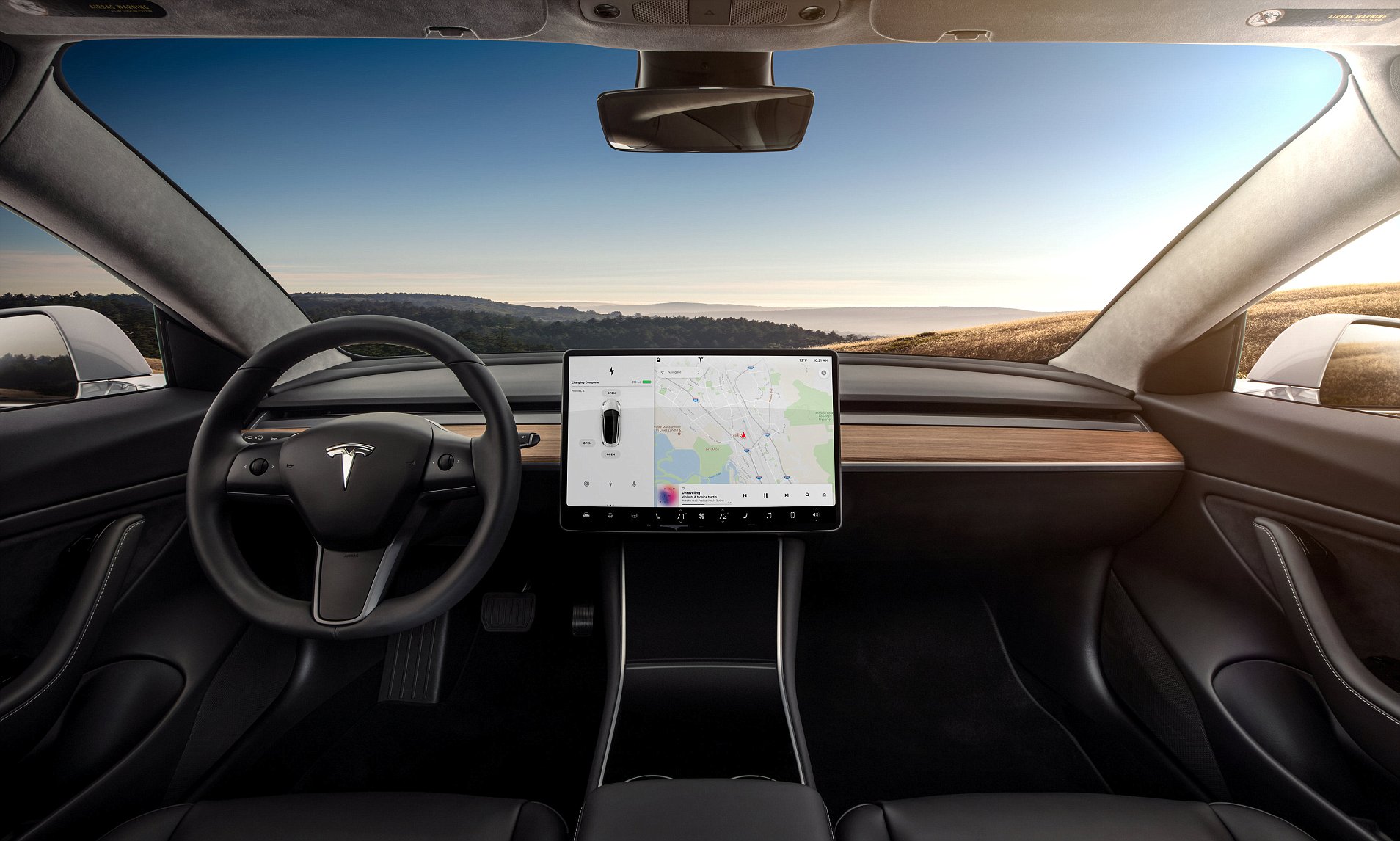 A mockup of a 2017 Tesla Model 3 interior, showing the entire dashboard. To the left is the steering wheel, in the center is a large touchscreen, but there's no other controls or displays, not even a speedometer gauge.