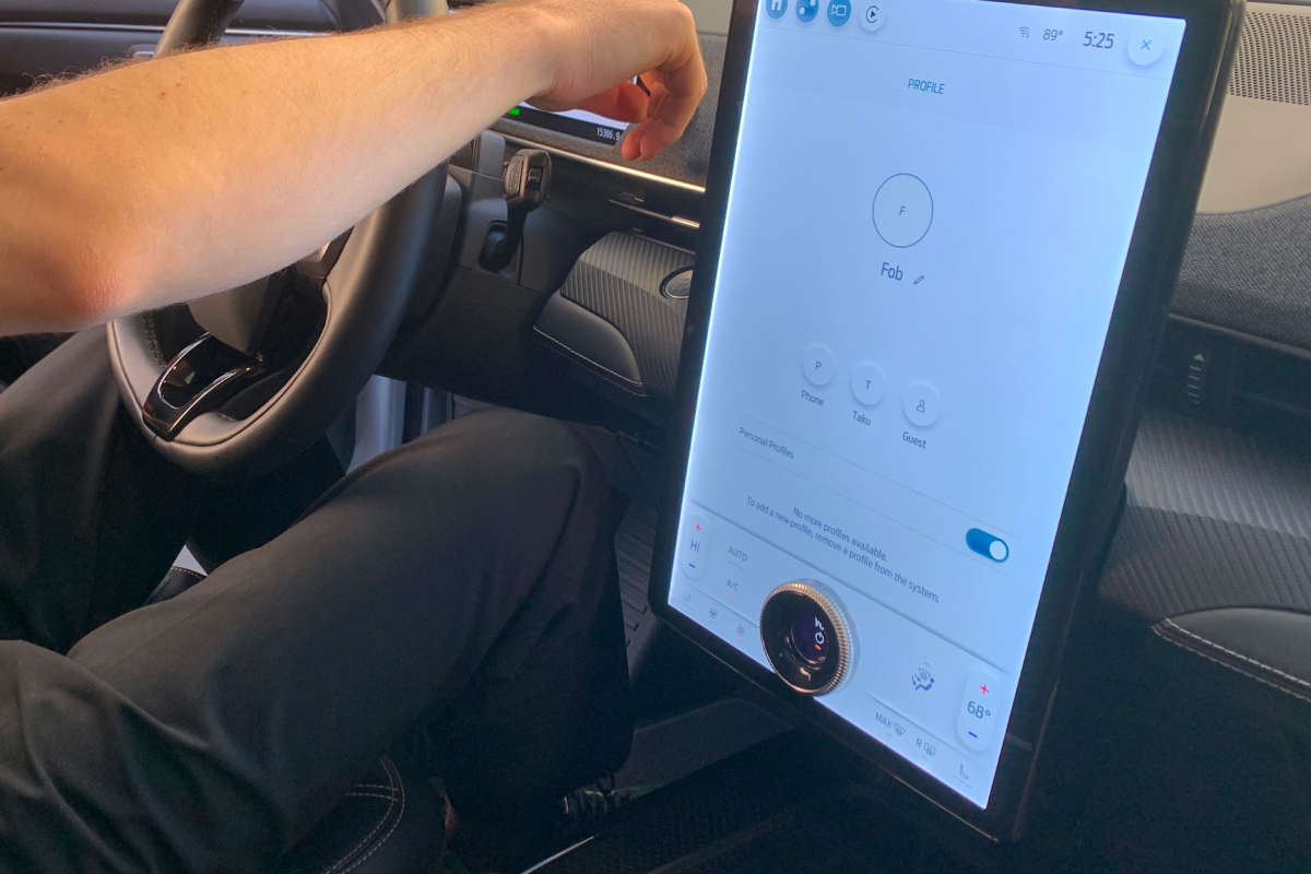 A photo of the dashboard of Ford's Mach-e SUV, showing the center touch screen which is punctuated with a knob control inset at the bottom of the screen.