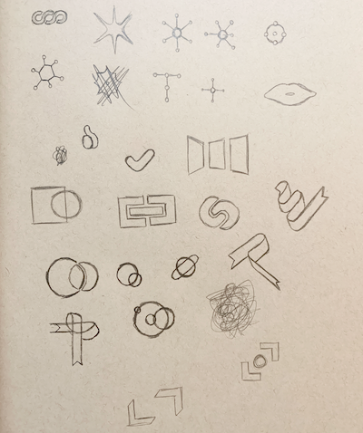 A notebook page of rough sketches of abstract shapes, motifs like a ribbon and interlocking shapes, iconographic shapes like a starburst, and more.